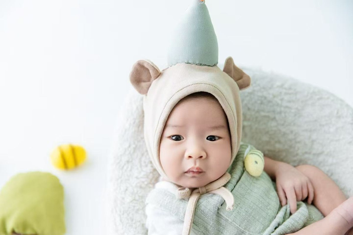 18天的登登，穿绿色小衣服安静躺着